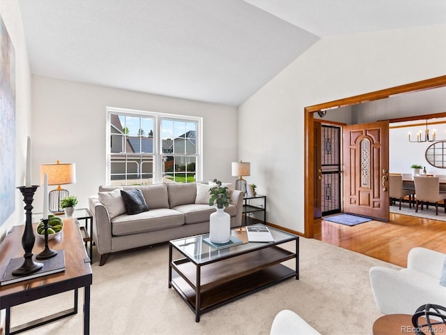 living area featuring baseboards, lofted ceiling, light wood-style flooring, a notable chandelier, and light colored carpet