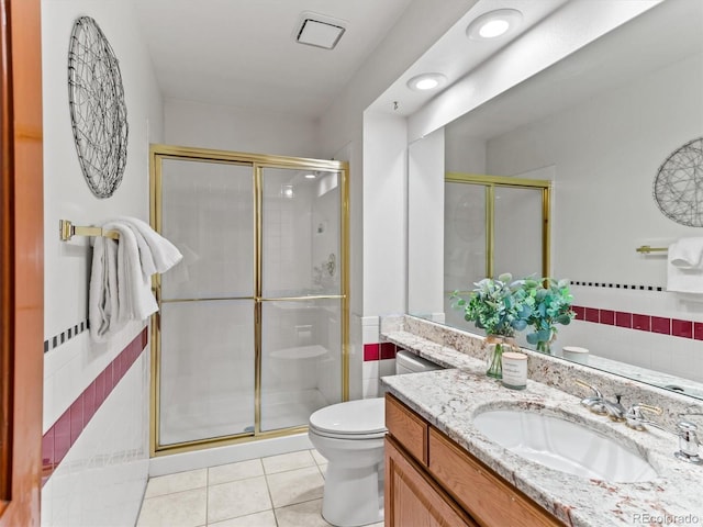 bathroom with tile patterned flooring, toilet, vanity, and a stall shower