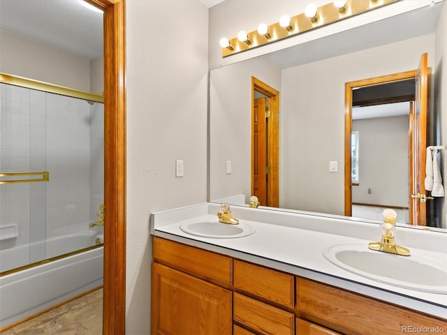 bathroom with double vanity, enclosed tub / shower combo, and a sink