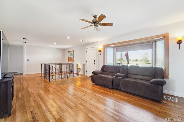 living room with ceiling fan and light hardwood / wood-style flooring