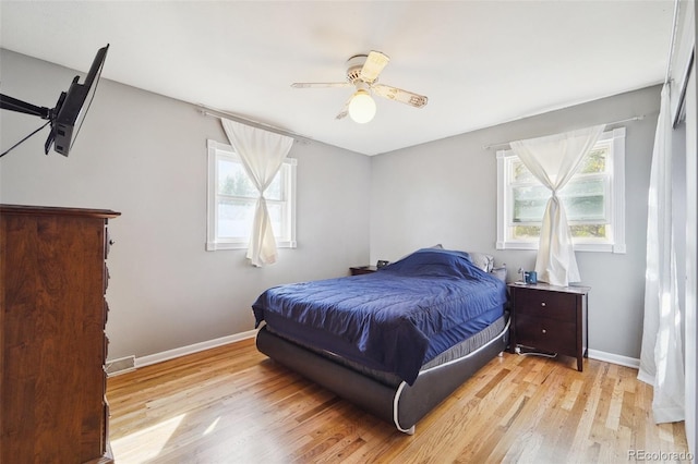 bedroom with multiple windows, light wood-type flooring, and ceiling fan