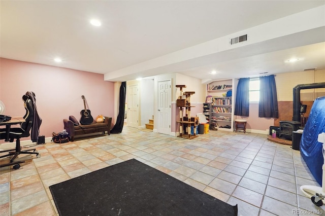5142 Buffalo Rd, Erie, CO 80516 - exercise room featuring tile patterned floors, a wood stove, baseboards, and visible vents