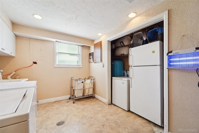 interior space featuring white cabinetry, white fridge, a textured ceiling, washer and clothes dryer, and electric panel