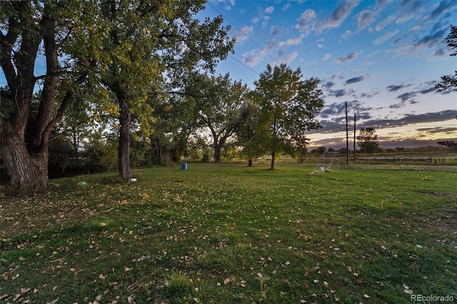 yard at dusk featuring a rural view