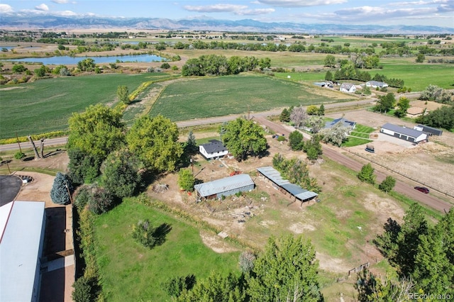 drone / aerial view with a water and mountain view and a rural view