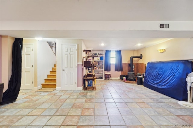 5142 Buffalo Rd, Erie, CO 80516 - below grade area featuring a wood stove, baseboards, visible vents, and stairs