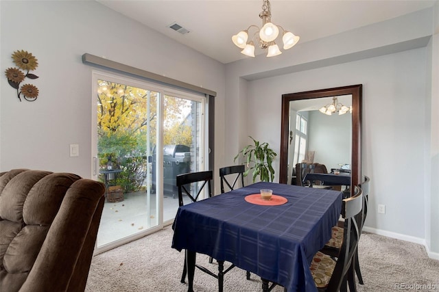 carpeted dining room featuring a notable chandelier