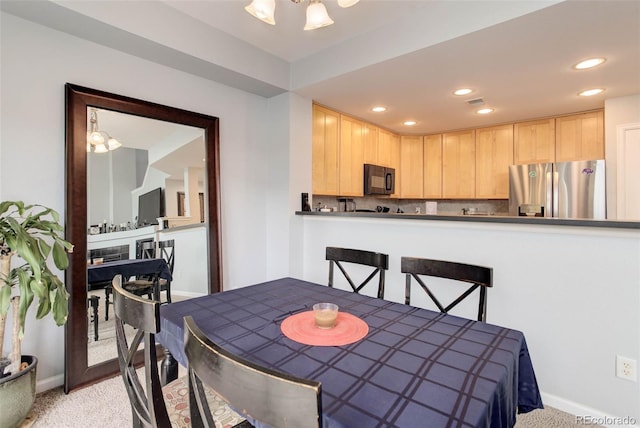 carpeted dining area featuring an inviting chandelier