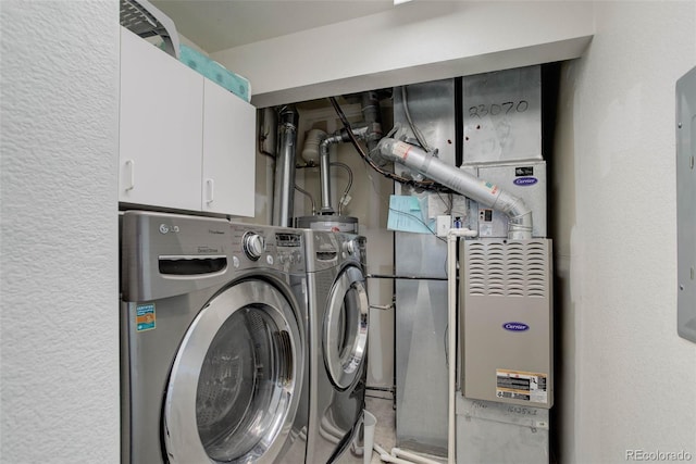 clothes washing area with washing machine and dryer and cabinets