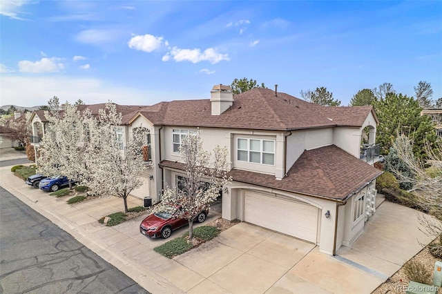 view of front of property featuring a shingled roof, a garage, stucco siding, a chimney, and concrete driveway