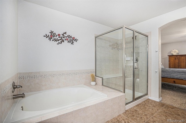 full bathroom featuring a garden tub, a stall shower, tile patterned flooring, and ensuite bath