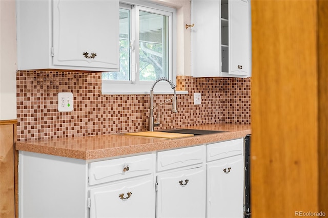 1280 Xanadu St, Aurora, CO 80011 - kitchen featuring white cabinetry, decorative backsplash, and light countertops