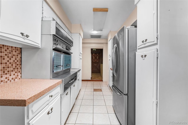 1280 Xanadu St, Aurora, CO 80011 - kitchen featuring freestanding refrigerator, white cabinets, and tasteful backsplash
