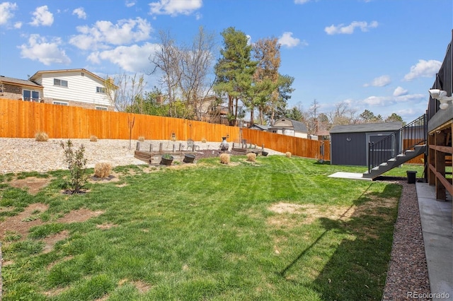 view of yard featuring stairway, an outdoor structure, a fenced backyard, and a storage unit
