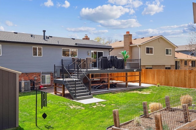 back of property with a lawn, a wooden deck, stairway, a fenced backyard, and a patio area