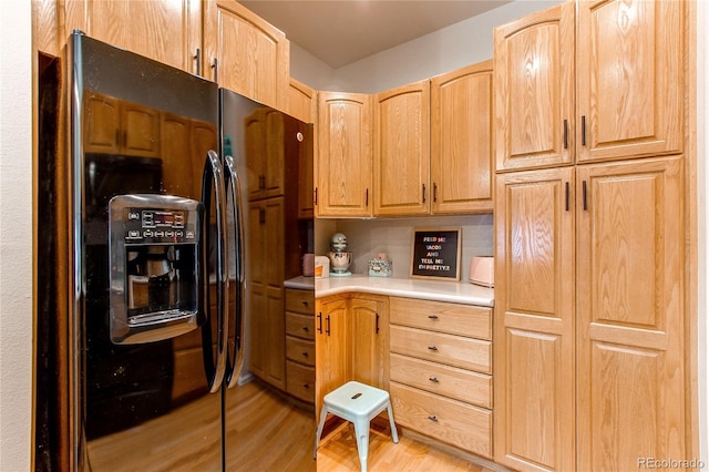 kitchen featuring black fridge with ice dispenser and light hardwood / wood-style floors