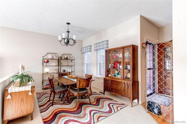 carpeted dining space featuring a textured ceiling and a notable chandelier