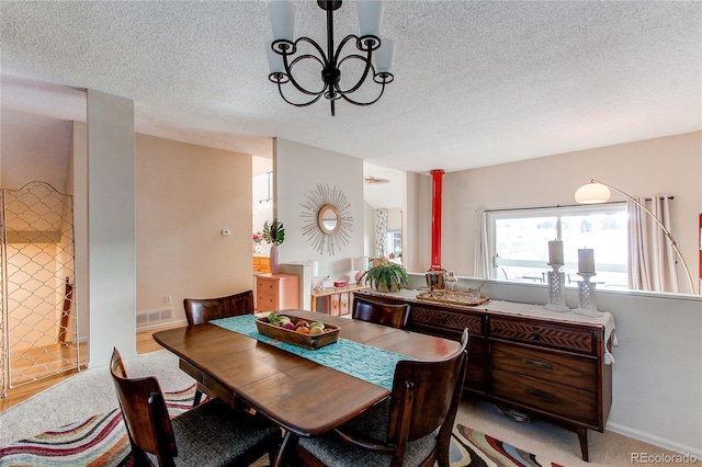 carpeted dining area featuring a textured ceiling and an inviting chandelier