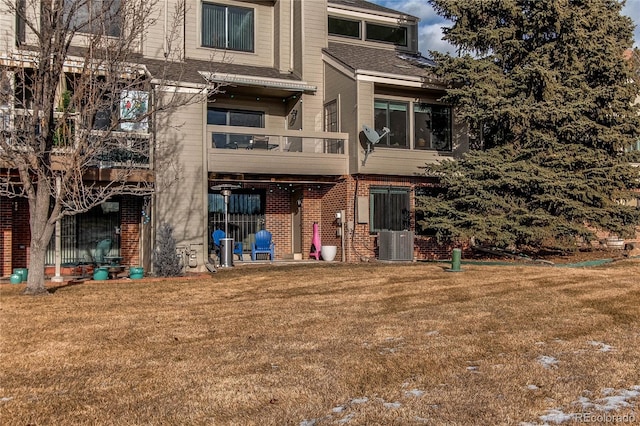 rear view of house with cooling unit and a yard