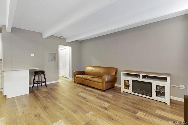 sitting room featuring light wood-type flooring and beamed ceiling