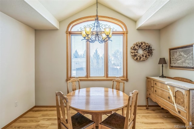 dining space with baseboards, light wood-type flooring, an inviting chandelier, and lofted ceiling