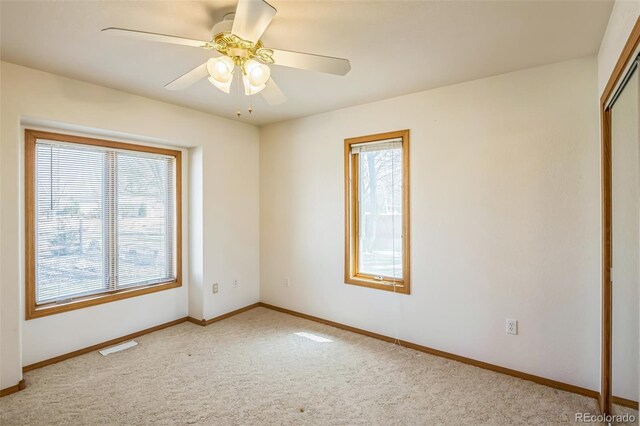empty room with ceiling fan, carpet flooring, and baseboards