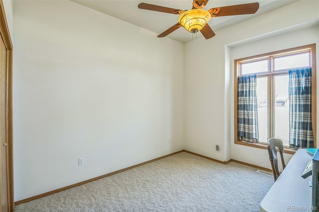 office space featuring visible vents, baseboards, a ceiling fan, and light carpet