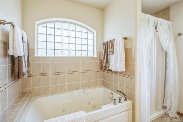 full bathroom with tile walls, a shower with shower curtain, and a jetted tub