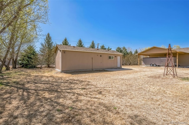 back of house featuring an outbuilding