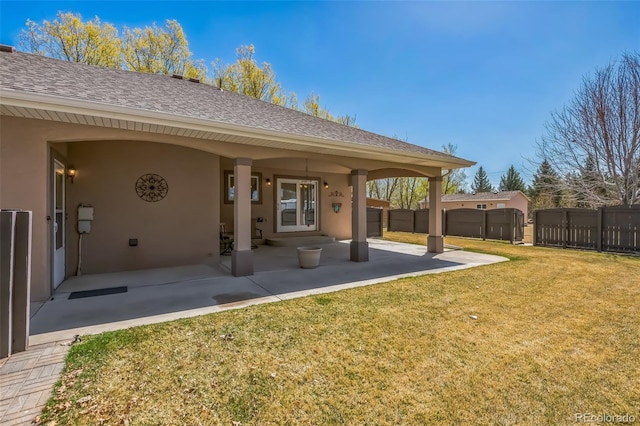 back of house with a yard, fence, and stucco siding