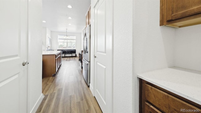 hallway with light hardwood / wood-style floors