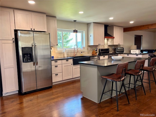 9081 Range Ln, Salida, CO 81201 - kitchen featuring stainless steel appliances, dark countertops, wall chimney range hood, dark wood-style floors, and tasteful backsplash