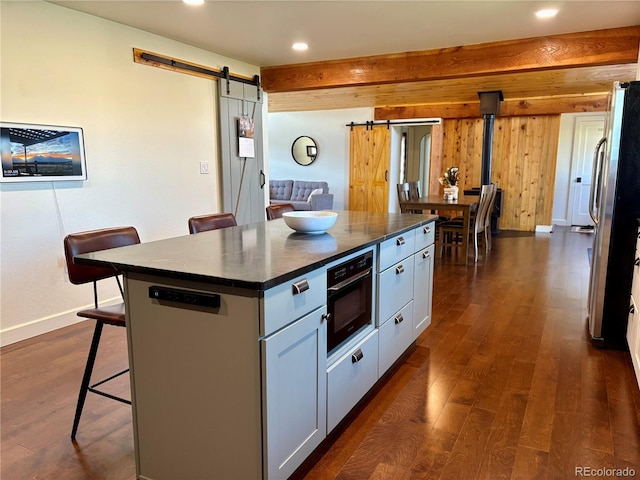 9081 Range Ln, Salida, CO 81201 - kitchen featuring a barn door, dark countertops, a breakfast bar area, dark wood finished floors, and recessed lighting