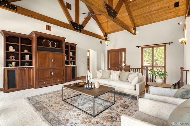 carpeted living area featuring visible vents, beam ceiling, wooden ceiling, arched walkways, and high vaulted ceiling