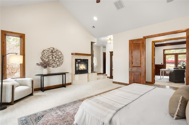 carpeted bedroom with visible vents, baseboards, high vaulted ceiling, and a fireplace