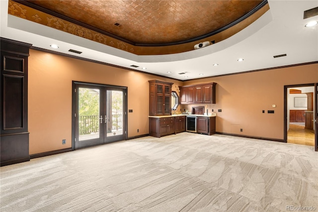 unfurnished living room with light colored carpet, baseboards, and a tray ceiling