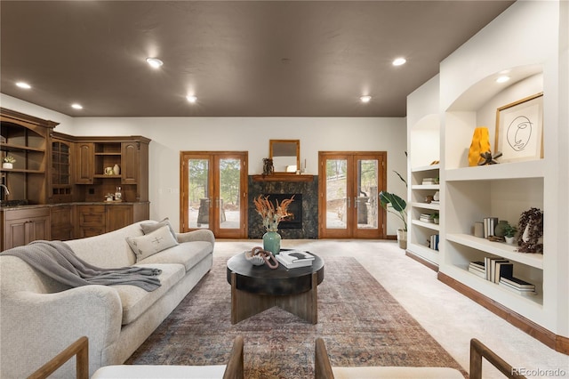 living area with a wealth of natural light, french doors, light colored carpet, and recessed lighting