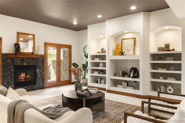 living area with built in features, a premium fireplace, carpet, and french doors