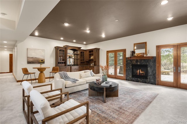 living area featuring a wealth of natural light, recessed lighting, light colored carpet, and french doors