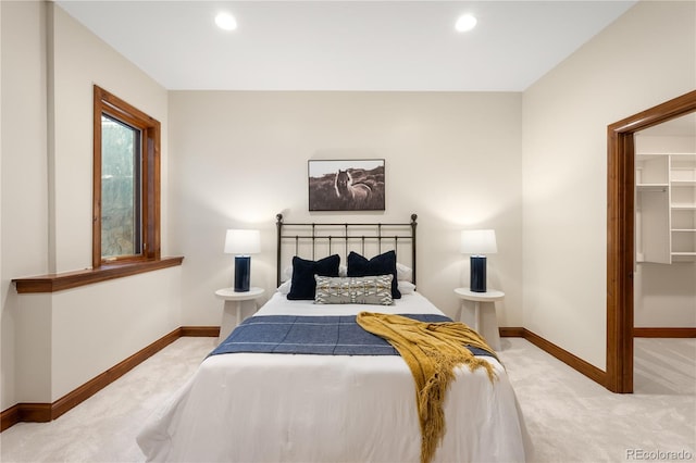 carpeted bedroom featuring a spacious closet, recessed lighting, and baseboards