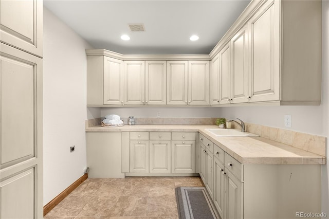 laundry area featuring visible vents, recessed lighting, baseboards, and a sink