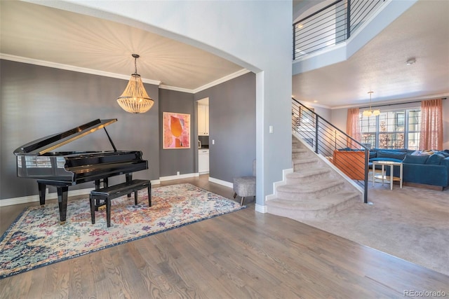 entrance foyer featuring crown molding, wood-type flooring, and an inviting chandelier