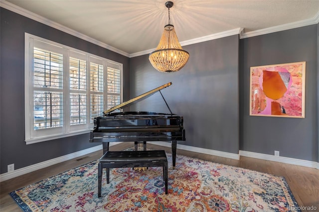 sitting room featuring ornamental molding, wood-type flooring, and a notable chandelier