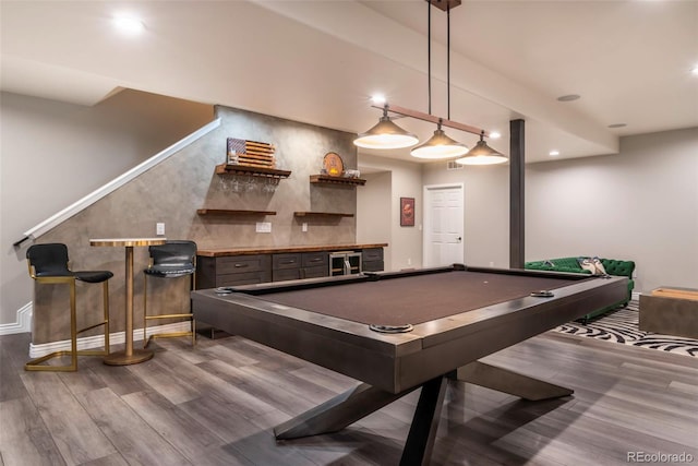 recreation room with hardwood / wood-style flooring, pool table, and bar area