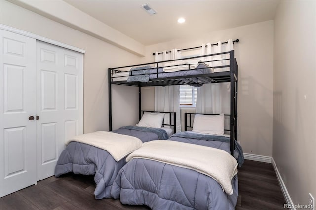 bedroom featuring dark wood-type flooring and a closet