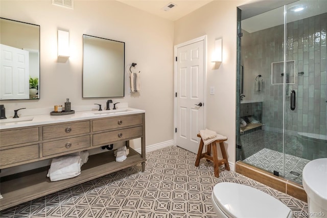 bathroom featuring vanity, tile patterned flooring, toilet, and walk in shower