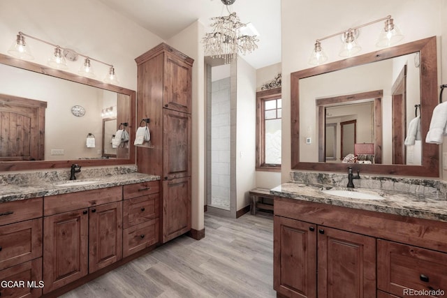 2621 Gcr 519, Tabernash, CO 80478 - bathroom with two vanities, a chandelier, and wood finished floors