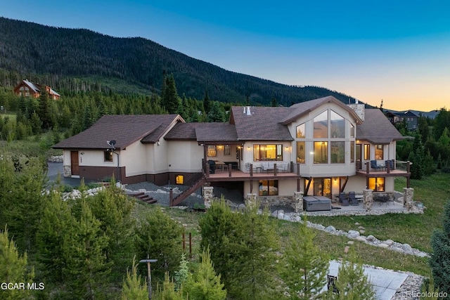 2621 Gcr 519, Tabernash, CO 80478 - back of house with a jacuzzi, a patio area, a deck with mountain view, stairway, and stucco siding