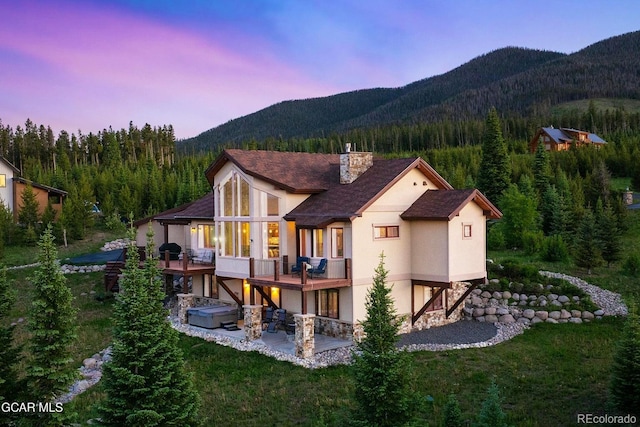 2621 Gcr 519, Tabernash, CO 80478 - back of property with a chimney, a patio area, stucco siding, and a wooded view