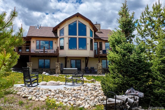 2621 Gcr 519, Tabernash, CO 80478 - rear view of house featuring a balcony, stucco siding, stone siding, a patio, and a chimney